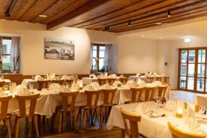 ein Bankettsaal mit weißen Tischen und Stühlen in der Unterkunft Zum Posthalter in Hemau