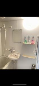 a white bathroom with a sink and a bath tub at 都心の家30 square meter king size bed, step meter, 3-person room201 in Tokyo