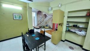 a dining room with a table and a room with stairs at The Nest - Garwa in Miraj