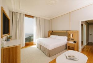 een hotelkamer met een bed en een groot raam bij METT Barcelona GL - A Leading Hotel of the World in Barcelona +48 foto's