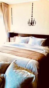 une chambre avec un lit avec un lustre au-dessus dans l'établissement Noble Remix Thonglor - Direct BTS Access - Super Fast Wi-Fi, à Bangkok 23 autres photos