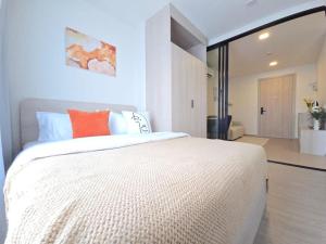 a bedroom with a large white bed with an orange pillow at Dcondo Reef Phuket in Kathu +9 photos