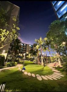 a park in front of a building at night at Dcondo Reef Phuket in Kathu