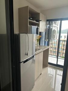 a kitchen with a white refrigerator in a room at Dcondo Reef Phuket in Kathu