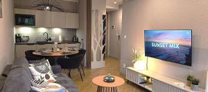 un salon avec un canapé et une télévision sur un mur dans l'établissement Sea & Forest - Apartamenty Może nad Morze, Parking, basen, siłownia GRATIS, à Międzyzdroje 59 autres photos