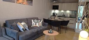 un salon avec un canapé et une cuisine dans l'établissement Sea & Forest - Apartamenty Może nad Morze, Parking, basen, siłownia GRATIS, à Międzyzdroje