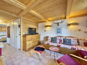 een woonkamer met een bank en een tv bij SO206 Grand 2 pieces style chalet Les Menuires in Les Menuires