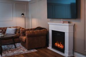 Una sala de estar con chimenea y un televisor encima. en Haparanda Stadshotell, en Haparanda