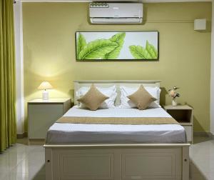 a bedroom with a bed with leaves on the wall at Opal Heights in Gampaha