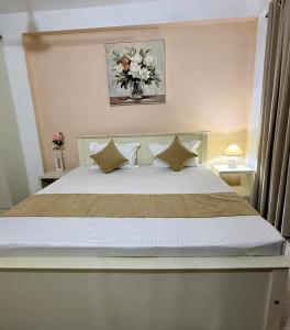 a bedroom with a large white bed with pillows at Opal Heights in Gampaha