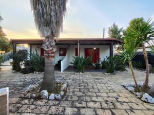 a house with a palm tree in front of it at Villa Pizzomunno a Vieste con accesso diretto alla Spiaggia di Pizzomunno in Vieste