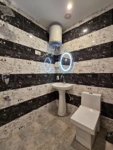 a bathroom with a sink and a toilet at Aangan Royal Stay in Dharmsala