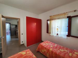 a bedroom with a red door and a red bed at Villa Pizzomunno a Vieste con accesso diretto alla Spiaggia di Pizzomunno in Vieste