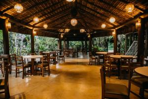 Un restaurante con mesas, sillas y luces. en Pousada Todas as Luas, en Ubatuba