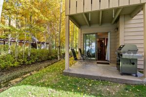 a house with a grill and chairs on a patio at RMR: Foxtail 5113 Condo in The AspensWilsonWY in Wilson