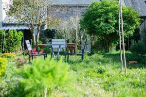 un jardín con mesa y sillas en el césped en La Maison Qui Ronronne, en Riec-sur-Bélon