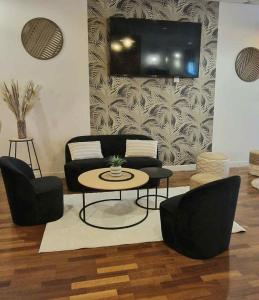 a living room with a couch and a table and chairs at B&B HOTEL Rouen Centre in Rouen