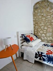 a bedroom with a bed and a stone wall at L'angolino di Ale in Sulmona