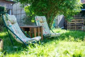 Dos sillas y una mesa en un patio. en La Maison Qui Ronronne, en Riec-sur-Bélon