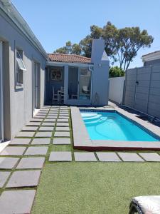 a backyard with a swimming pool and a house at Naliya Guest house in Cape Town