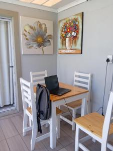 a dining room with a table with a laptop on it at Naliya Guest house in Cape Town +28 photos
