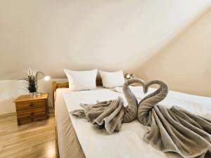 two towel swans sitting on a bed in a bedroom at FH Butt in Blengow