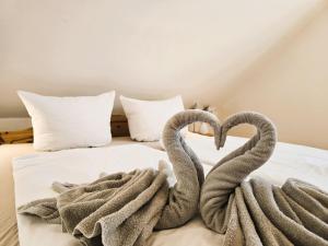 two towel swans making a heart on a bed at FH Butt in Blengow