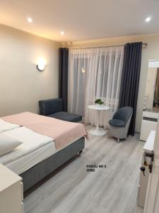 a bedroom with a bed and a table and chairs at Willa Maja in Ciechocinek