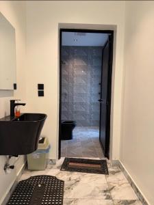baño con lavabo negro y aseo en شاليه داله العماريه1 بالكامل لك وأجواء ممتعه, en Abā al Kibāsh