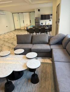 una sala de estar con un sofá grande y mesas. en شاليه داله العماريه1 بالكامل لك وأجواء ممتعه, en Abā al Kibāsh