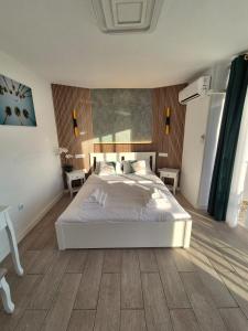 a bedroom with a white bed and a wooden floor at Palm Breeze - Las Americas in Playa de las Americas