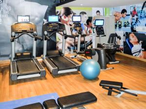 een vrouw in een sportschool met verschillende hometrainers bij ibis Bengaluru Hosur Road - An Accor Brand in Bangalore