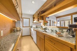 a kitchen with wooden cabinets and granite counter tops at RMR: Geranium 2621 Condo in The AspensWilsonWY in Wilson
