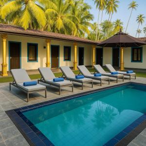 eine Gruppe von Liegestühlen neben einem Swimmingpool in der Unterkunft Eros Green House in Unawatuna