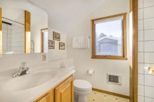 a bathroom with a sink and a toilet and a window at RMR: Geranium 2621 Condo in The AspensWilsonWY in Wilson