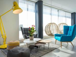 维也纳宜必思南利昂维埃纳圣路易酒店的客厅里有蓝色的椅子和桌子