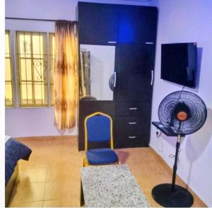 a living room with a blue chair and a fan at Short Let Apartments in Lagos Business School Lekki Ajah in Lekki