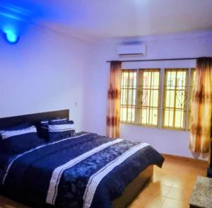 a bedroom with a bed and two windows at Short Let Apartments in Lagos Business School Lekki Ajah in Lekki +17 photos