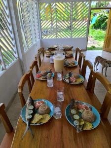 a wooden table with plates of food on it at Ibiza beach in Moñitos