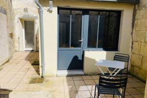 a table and two chairs in front of a door at Bel appartement avec cour privée in Saint-Jean-dʼAngély