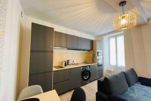 a living room with a couch and a kitchen at Bel appartement avec cour privée in Saint-Jean-dʼAngély