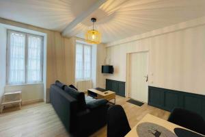 a living room with a couch and a table at Bel appartement avec cour privée in Saint-Jean-dʼAngély +7 photos