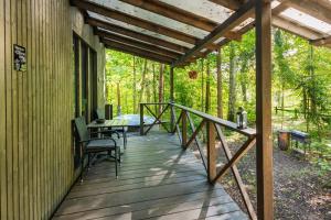 un porche de una casa con mesa y sillas en Meža māja, en Zaķumuiža