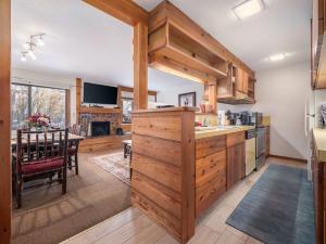a kitchen with wooden cabinets and a dining room at RMR: Chokeberry 3813 Condo in The Aspens in Wilson