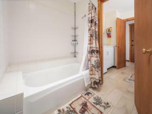 a bathroom with a tub and a shower curtain at RMR: Chokeberry 3813 Condo in The Aspens in Wilson