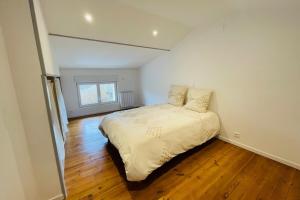 a bedroom with a bed in a room with wooden floors at La Maison de la Brousse in Brizambourg +6 photos