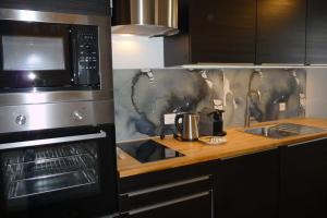 eine Küche mit Spüle und Mikrowelle in der Unterkunft Studio moderne rénové in Saint-Jean-dʼAngély