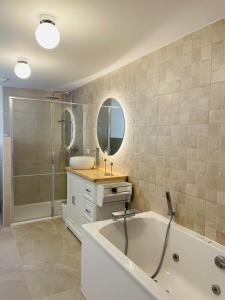 Un baño con bañera, lavabo y ducha. en La Touzetterie avec SPA-cour privée, en Saint-Jean-dʼAngély