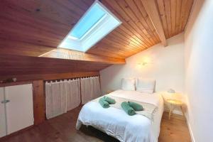 Un dormitorio con una cama grande con tragaluz. en La Touzetterie avec SPA-cour privée, en Saint-Jean-dʼAngély