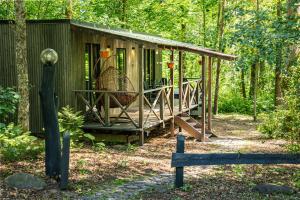 ZaķumuižaMeža māja的树林中带门廊的绿色小屋